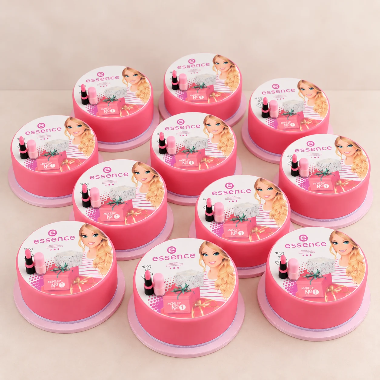 Multiple matching pink Essence branded individual cakes arranged together for a larger order