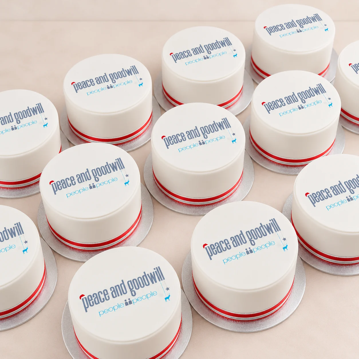 Multiple matching white corporate gift cakes with People2People peace and goodwill branding
